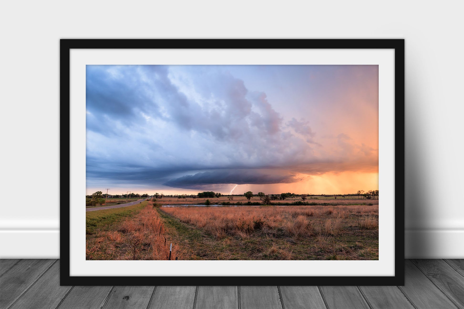 Framed and matted storm print of a supercell thunderstorm with a lightning bolt at sunset on a stormy evening on the Kansas prairie by Sean Ramsey of Southern Plains Photography.