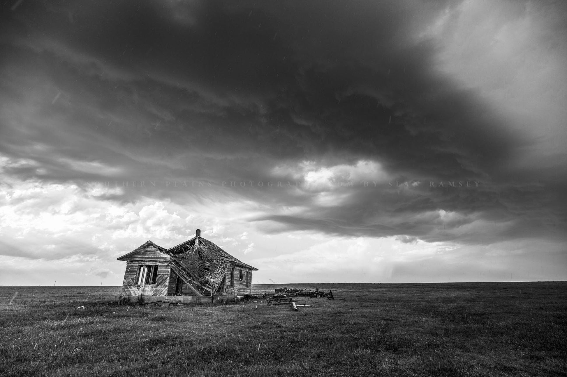 Rustic photography print of an old abandoned house weathers a thunderstorm as raindrops fall on a stormy spring day in Oklahoma in black and white by Sean Ramsey of Southern Plains Photography.