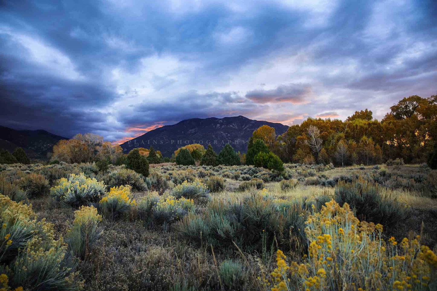 Rocky Mountain landscape photography print of Taos Mountain under a stormy sky at sunrise on an autumn morning near Taos, New Mexico by Sean Ramsey of Southern Plains Photography.