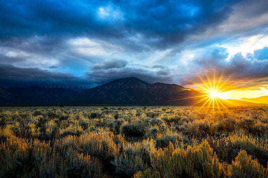 Southwestern photography print of the sun twinkling from behind Taos Mountain on a stormy morning near Taos, New Mexico by Sean Ramsey of Southern Plains Photography.