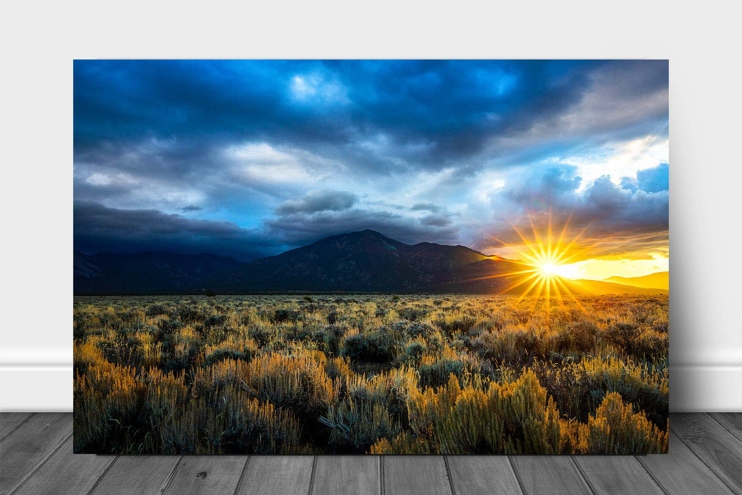 High desert landscape metal print wall art of the sun twinkling behind Taos Mountain as storm clouds move through over sagebrush on an autumn morning near Taos, New Mexico by Sean Ramsey of Southern Plains Photography.