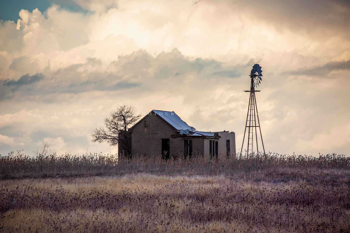 Country photography print of an abandoned homestead and windmill nestled in prairie grass on a stormy evening in the Oklahoma panhandle by Sean Ramsey of Southern Plains Photography.