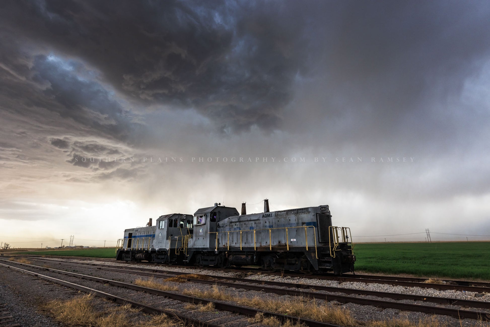 Train photography print of a thunderstorm advancing over locomotive engines on a stormy day on the plains of Oklahoma by Sean Ramsey of Southern Plains Photography.