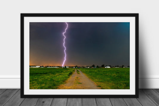 Framed and matted storm print of a lightning bolt striking from high above in the sky down a rural road on a stormy day in Oklahoma by Sean Ramsey of Southern Plains Photography.