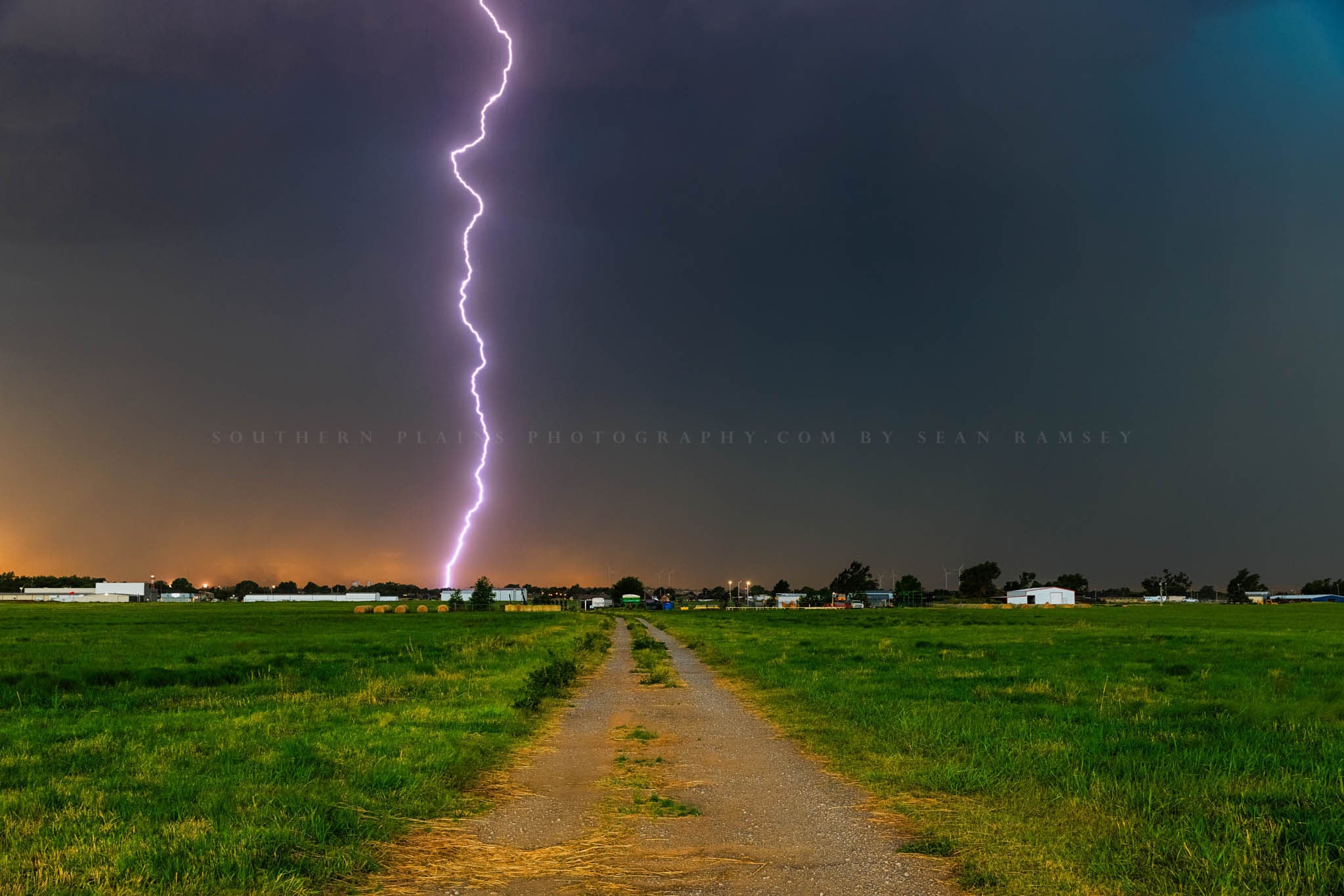 Storm photography print of a lightning bolt striking down a dirt road on a stormy summer evening in Oklahoma by Sean Ramsey of Southern Plains Photography.