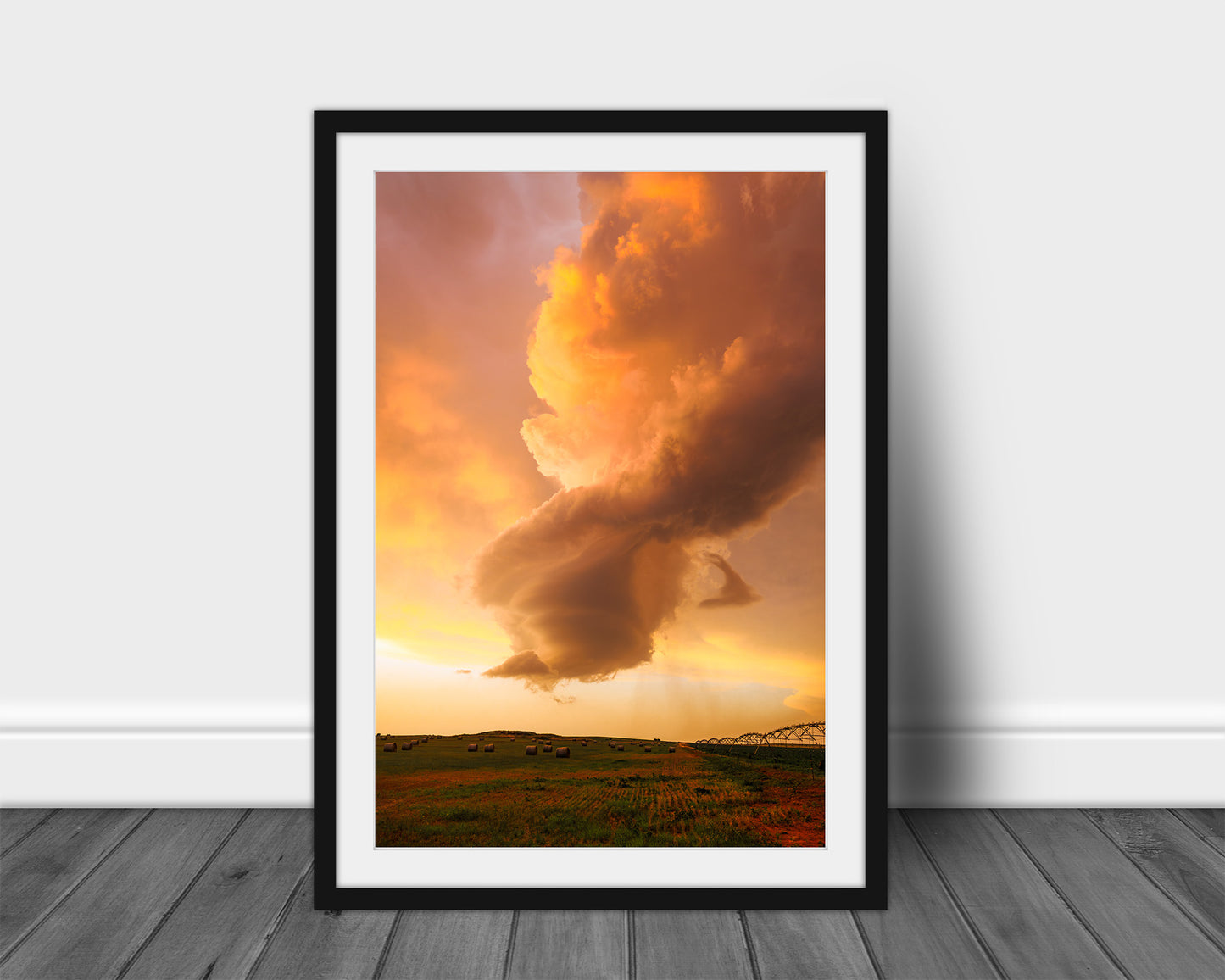 Stormy sky vertical framed print of a dissipating storm cloud that was once a supercell thunderstorm over a field drenched in evening sunlight at sunset in Oklahoma by Sean Ramsey of Southern Plains Photography.