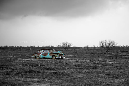 Black and white with color abandoned car photography print of an Olds 88 rusting away in a field on a stormy day in Texas by Sean Ramsey of Southern Plains Photography.