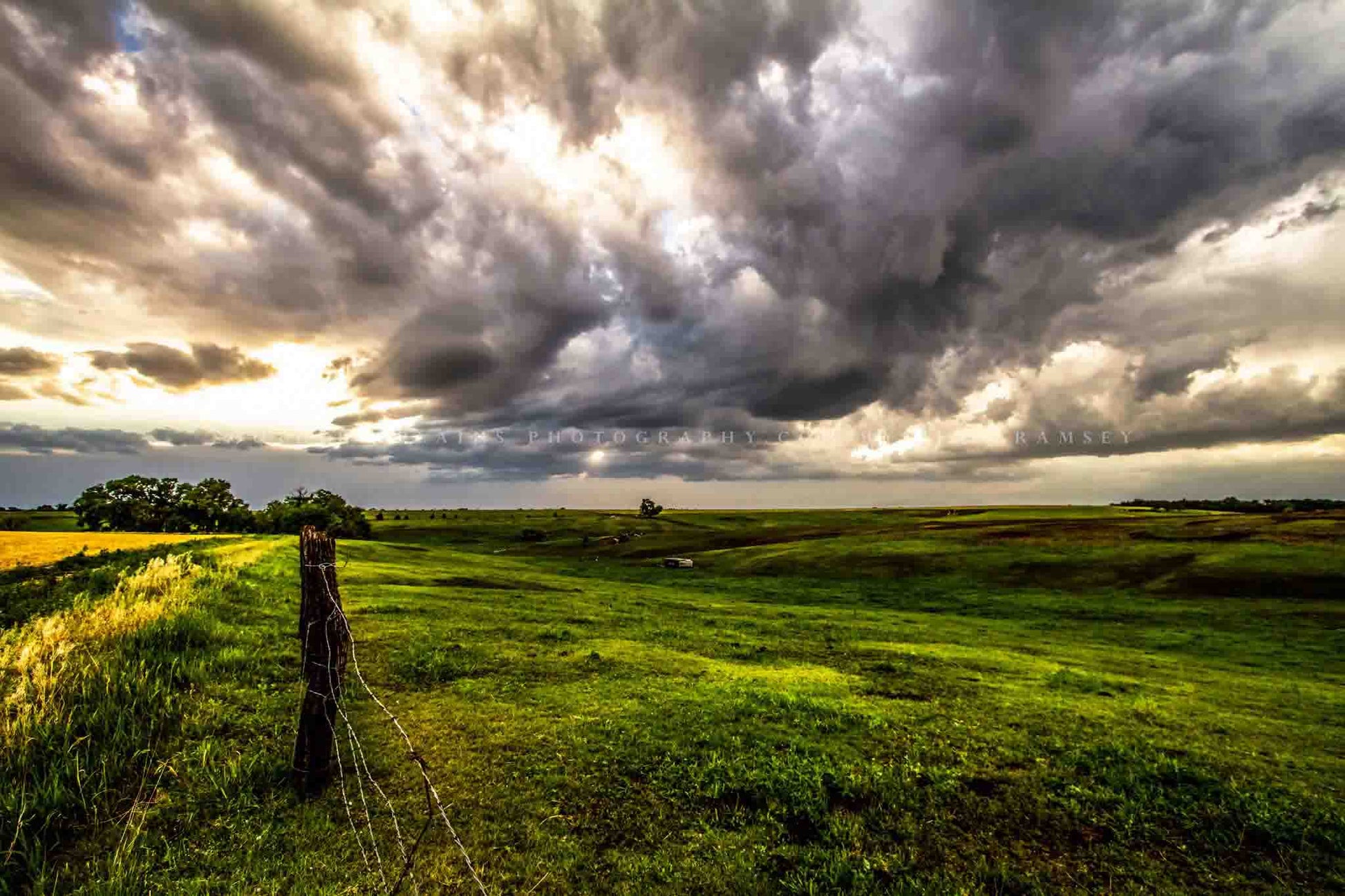 Great plains photography print of golden sunlight filtering through storm clouds and shining on the prairie on a stormy day in Nebraska by Sean Ramsey of Southern Plains Photography.