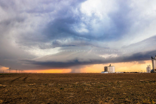 Storm photography print of a supercell thunderstorm filling the sky over a dusty field near a small town on a stormy spring evening in Kansas by Sean Ramsey of Southern Plains Photography.