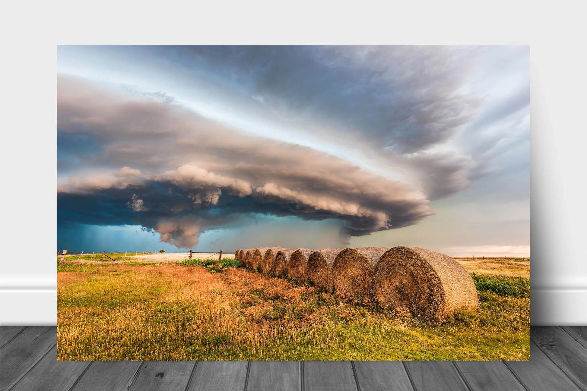 Storm aluminum metal print wall art of a massive supercell thunderstorm shelf cloud advancing over a row of hay bales on a stormy day on the plains of Oklahoma by Sean Ramsey of Southern Plains Photography.