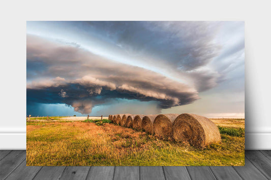 Storm aluminum metal print wall art of a massive supercell thunderstorm shelf cloud advancing over a row of hay bales on a stormy day on the plains of Oklahoma by Sean Ramsey of Southern Plains Photography.