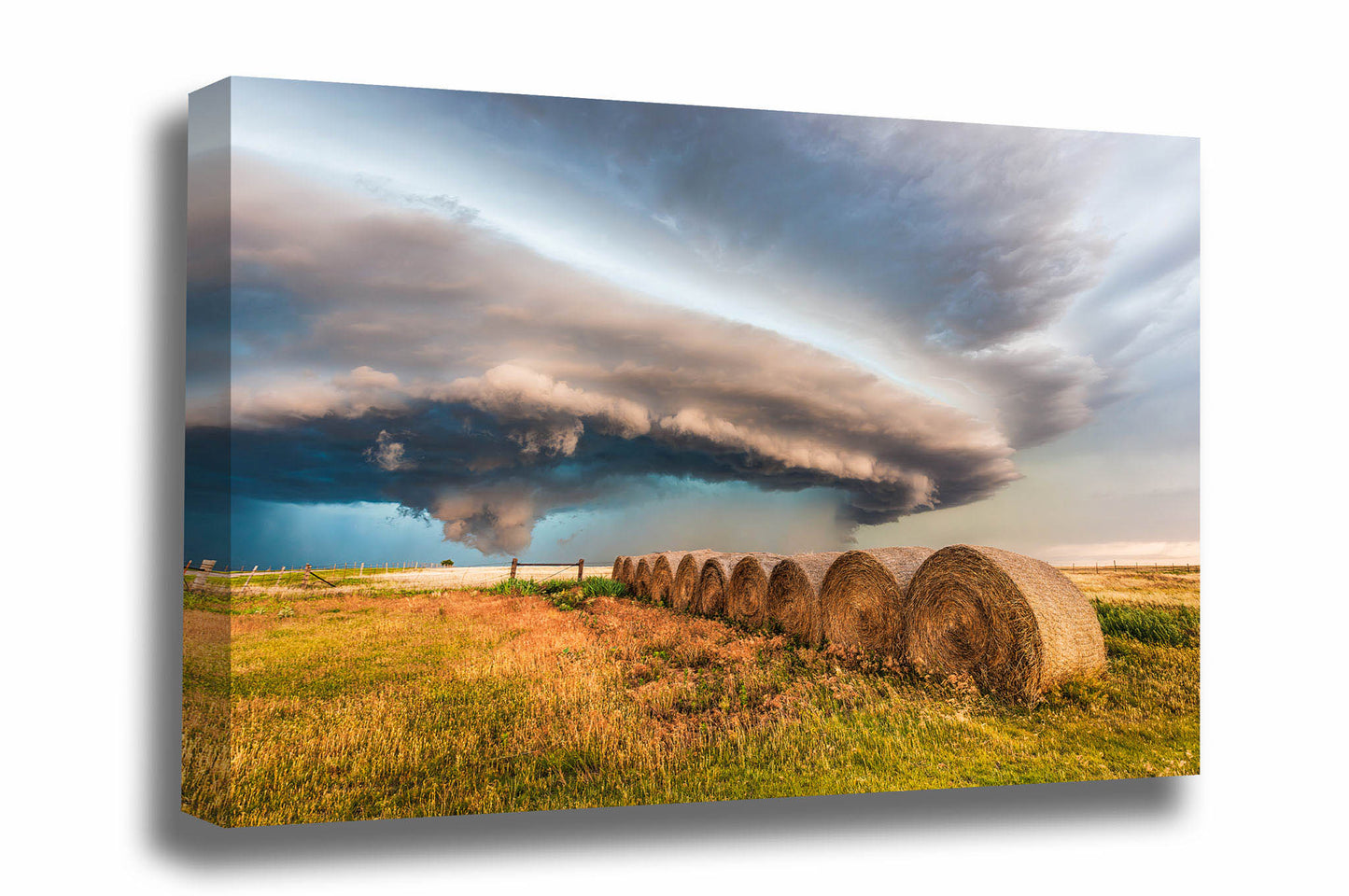 Storm canvas wall art of a massive supercell thunderstorm shelf cloud advancing over a row of hay bales on a stormy day on the plains of Oklahoma by Sean Ramsey of Southern Plains Photography.