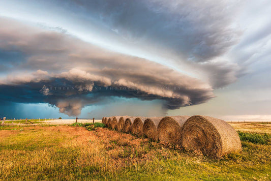 Storm photography print of a massive supercell thunderstorm shelf cloud advancing over a row of hay bales on a stormy day on the plains of Oklahoma by Sean Ramsey of Southern Plains Photography.