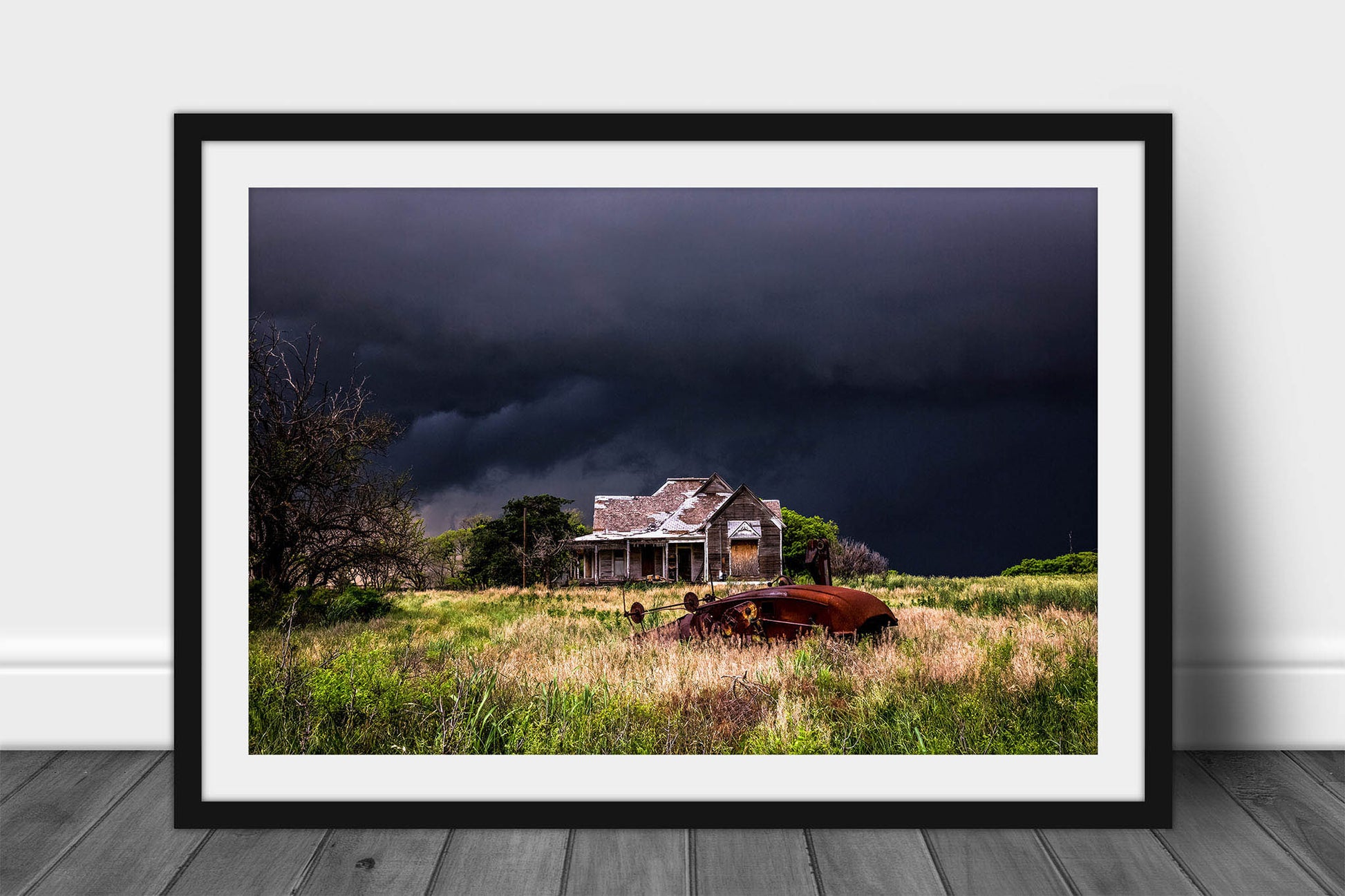 Framed and matted country print of an abandoned house with a classic cotton gin in the front yard as a storm passes behind on a stormy night in Texas by Sean Ramsey of Southern Plains Photography.