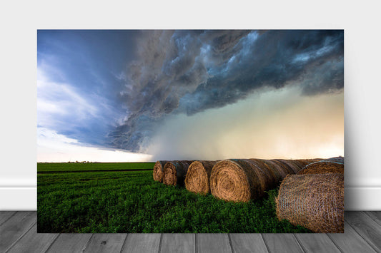 Storm metal print wall art on aluminum of a thunderstorm advancing over round hay bales on a stormy summer day in Kansas by Sean Ramsey of Southern Plains Photography.