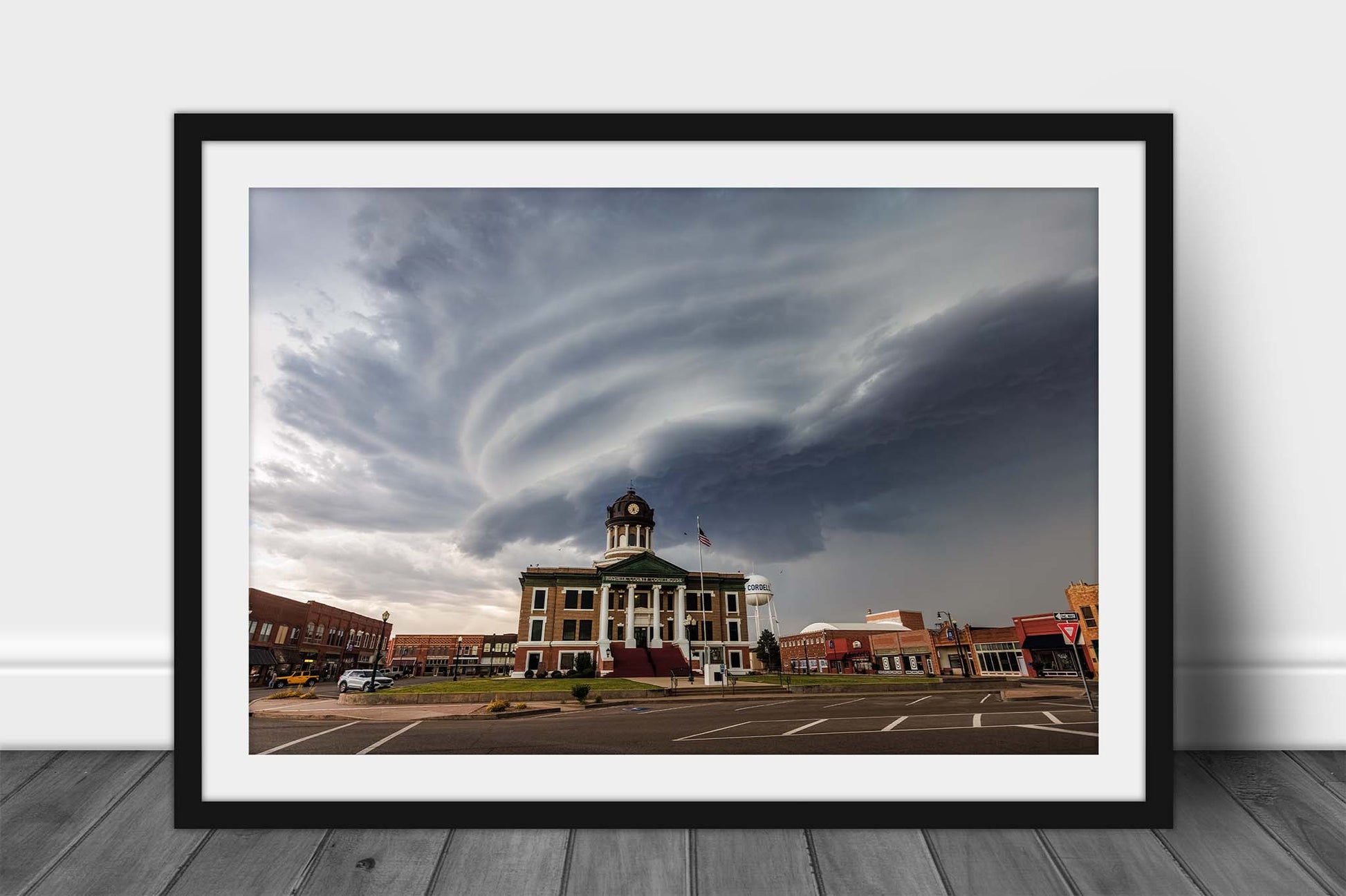 Framed storm print of a striated supercell thunderstorm advancing over the Washita County courthouse in Cordell, Oklahoma by Sean Ramsey of Southern Plains Photography.
