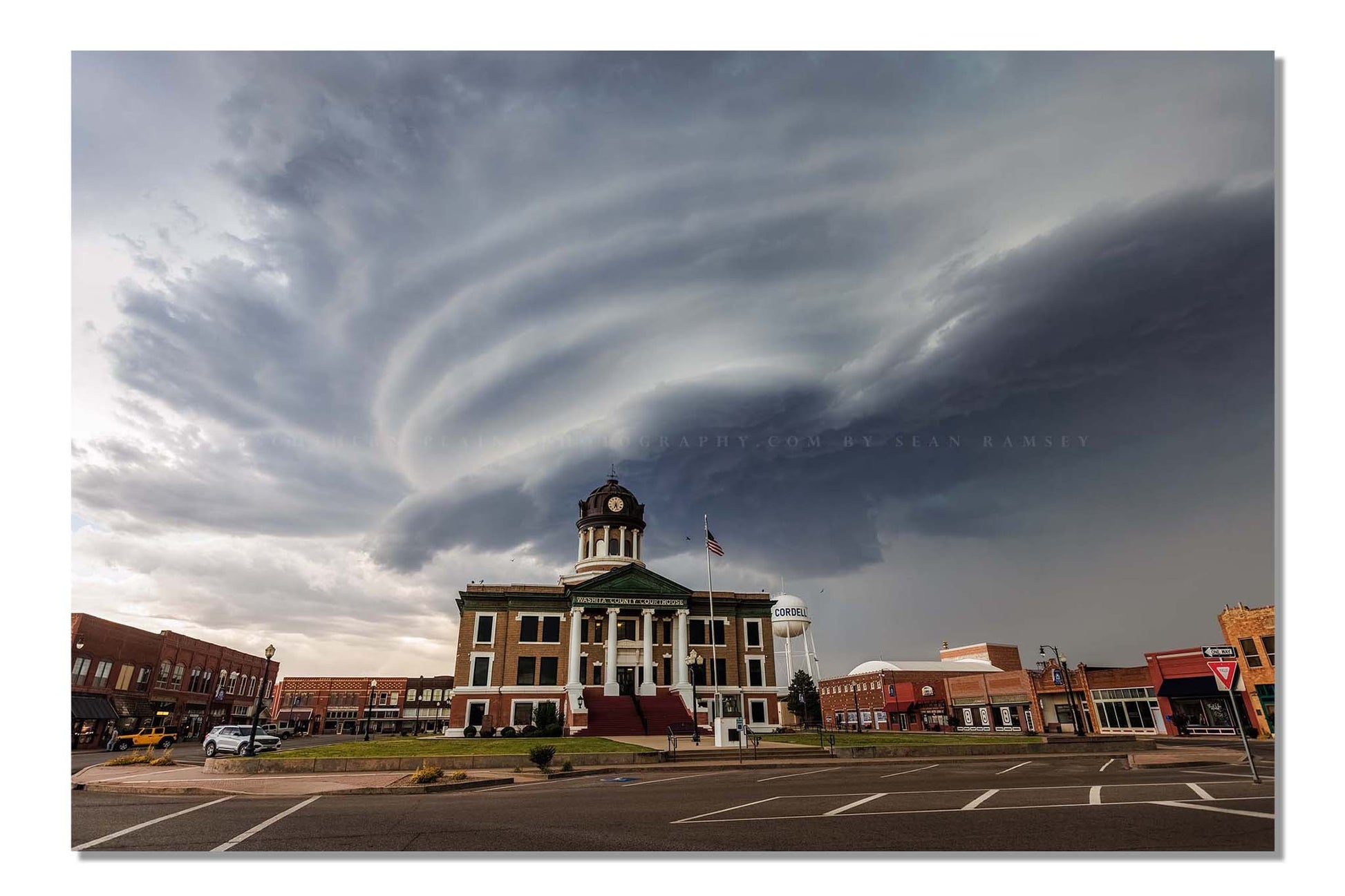 Storm photography print of a striated supercell thunderstorm advancing over the Washita County courthouse in Cordell, Oklahoma by Sean Ramsey of Southern Plains Photography.