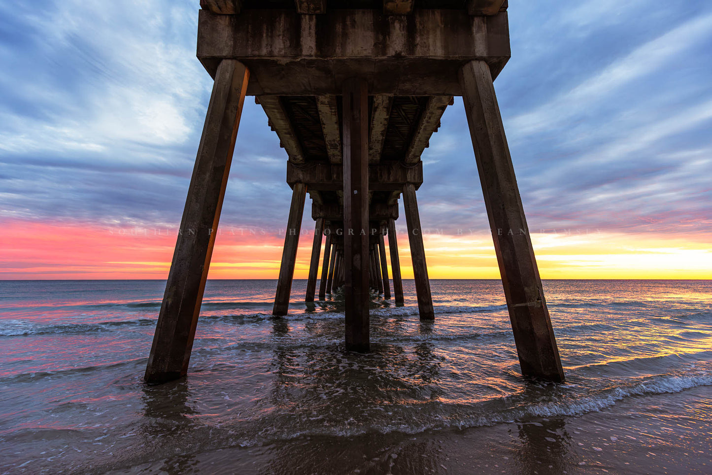 Gulf Coast photography print of a view of a beautiful sunset and waters of the Gulf of Mexico from under the Pensacola Beach Pier in Florida by Sean Ramsey of Southern Plains Photography.