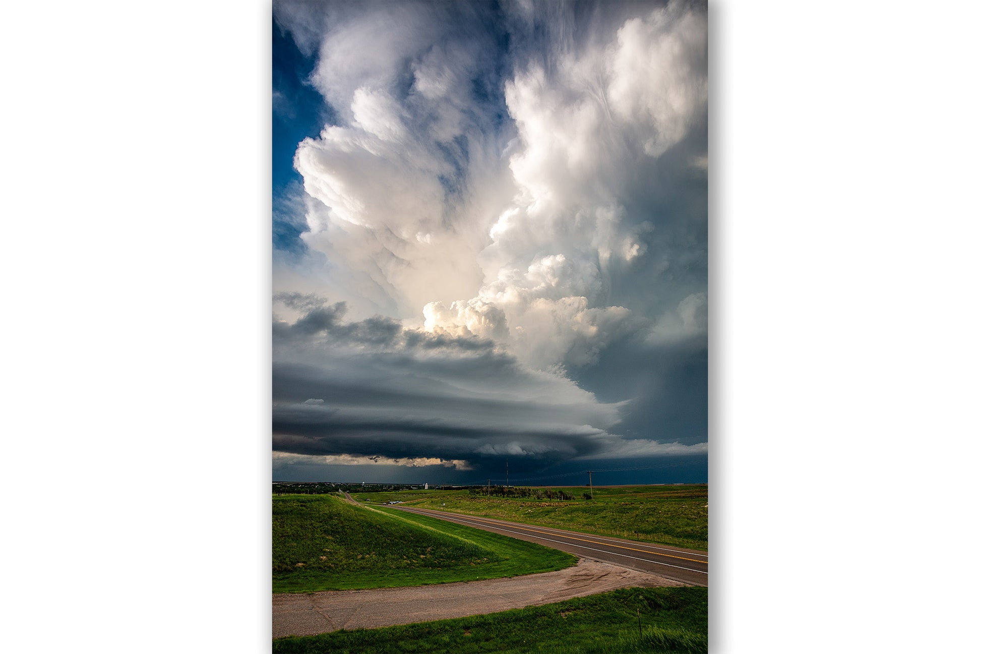 Vertical storm photography print of a supercell thunderstorm with a tall updraft over a highway on a stormy spring day in Kansas by Sean Ramsey of Southern Plains Photography.