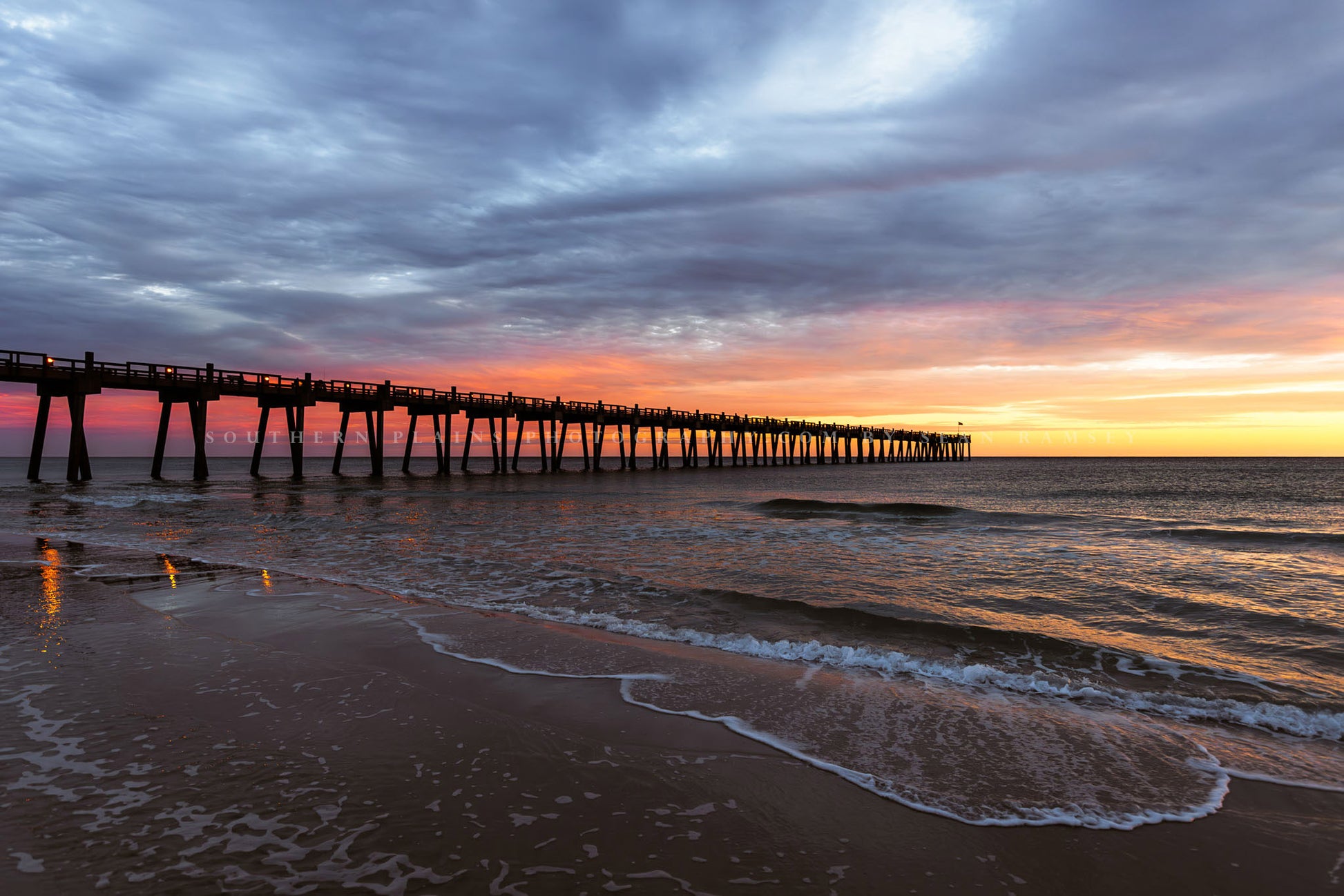 Gulf Coast photography print of the Pensacola Beach Pier extending into a colorful horizon as waves roll ashore at sunset in Florida by Sean Ramsey of Southern Plains Photography.