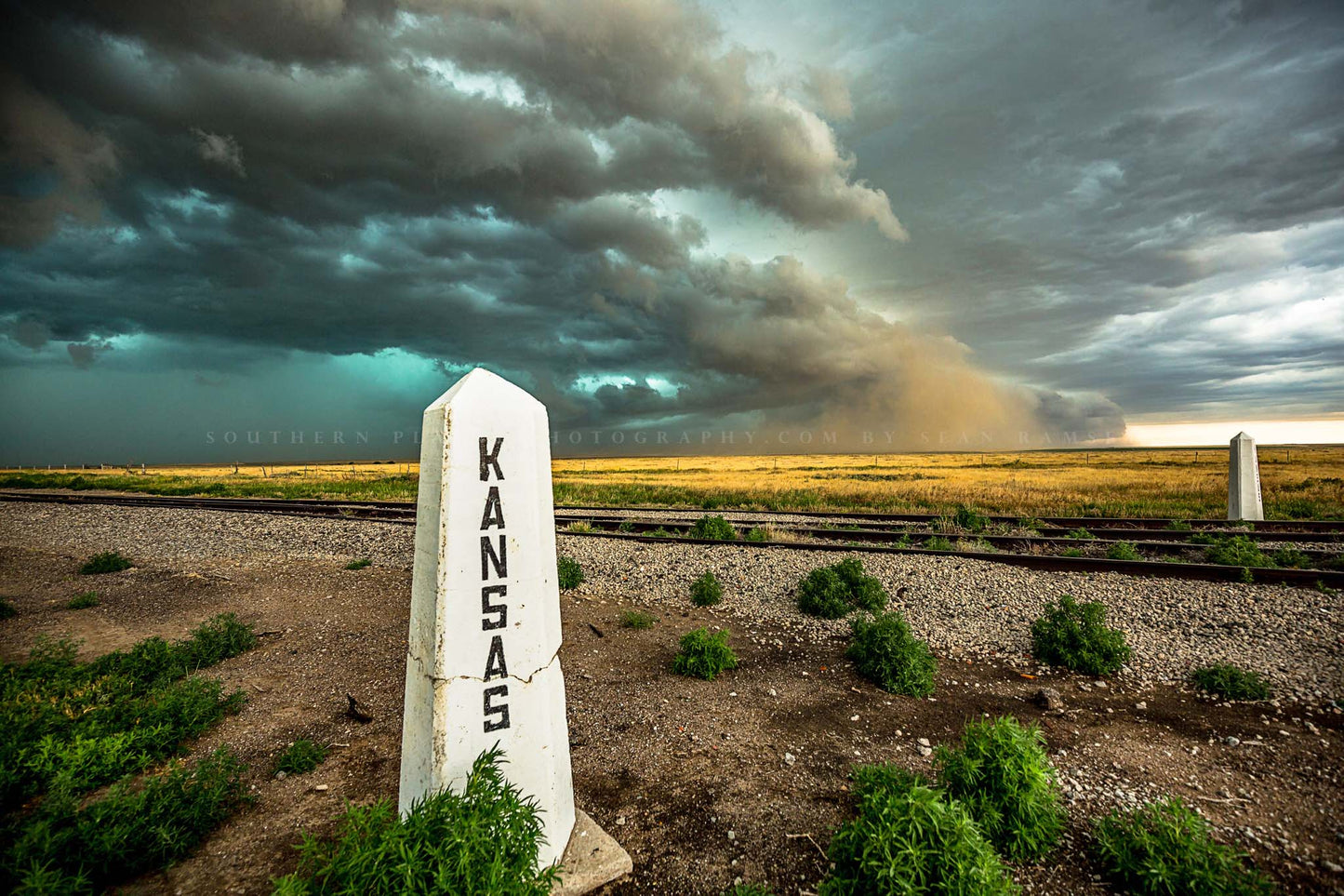 Great Plains photography print of a thunderstorm advancing past a railroad post on a stormy spring day at the state line of Kansas by Sean Ramsey of Southern Plains Photography.