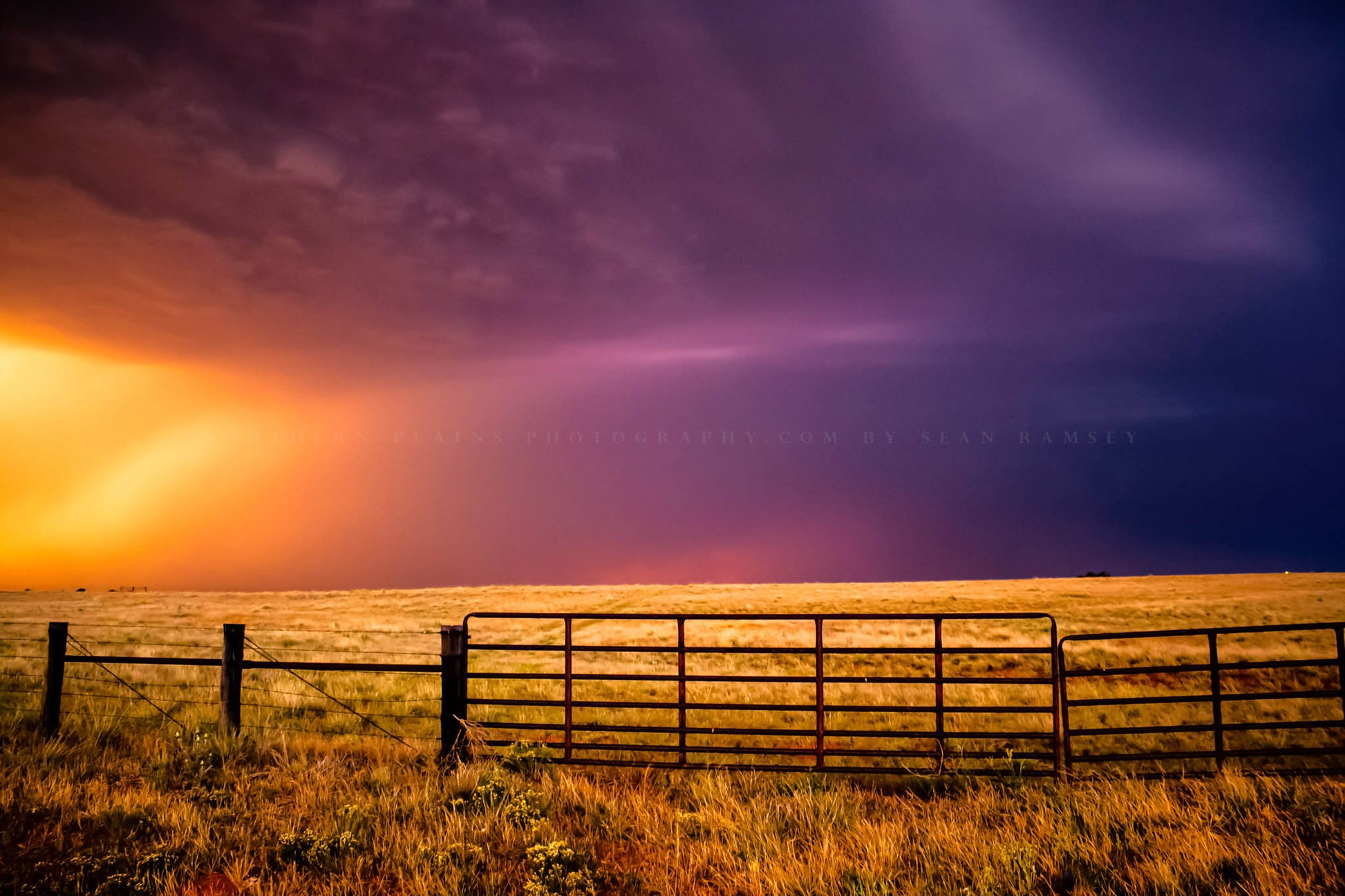 Country photography print of a colorful sky over a fence gate on a stormy day in western Oklahoma by Sean Ramsey of Southern Plains Photography.