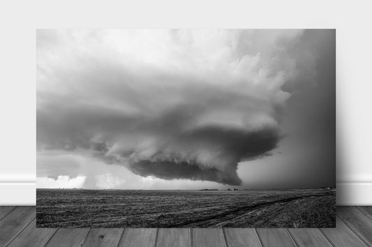 Black and white storm aluminum metal print of a supercell thunderstorm with wall cloud hovering over a barren field on a stormy day in Kansas by Sean Ramsey of Southern Plains Photography.