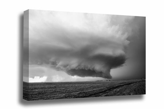 Black and white storm canvas wall art of a supercell thunderstorm with wall cloud hovering over a barren field on a stormy day in Kansas by Sean Ramsey of Southern Plains Photography.