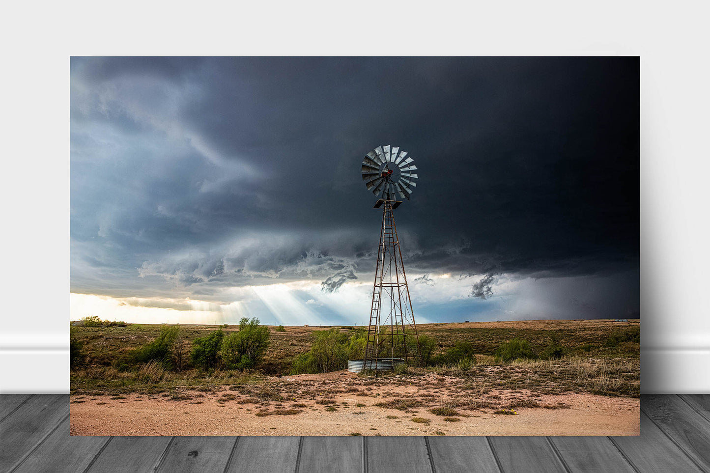 Country aluminum metal print wall art of sunbeams breaking through an intense storm as an Aermotor windmill stands tall over the prairie landscape on a spring day in Texas by Sean Ramsey of Southern Plains Photography.