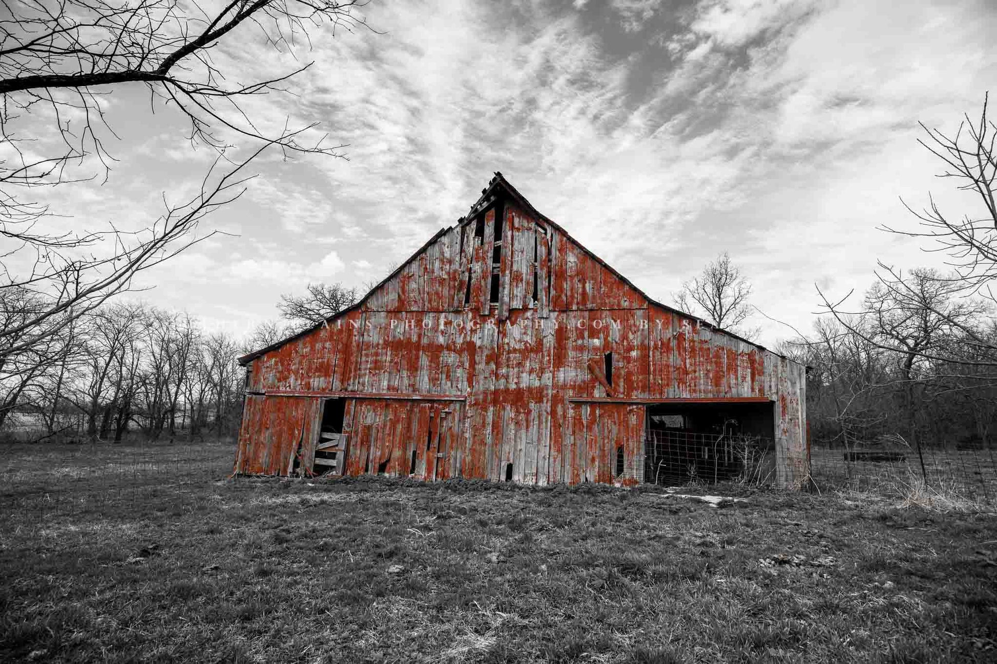 Country photography print of an old barn with worn red paint on a black and white farm landscape in Missouri by Sean Ramsey of Southern Plains Photography.