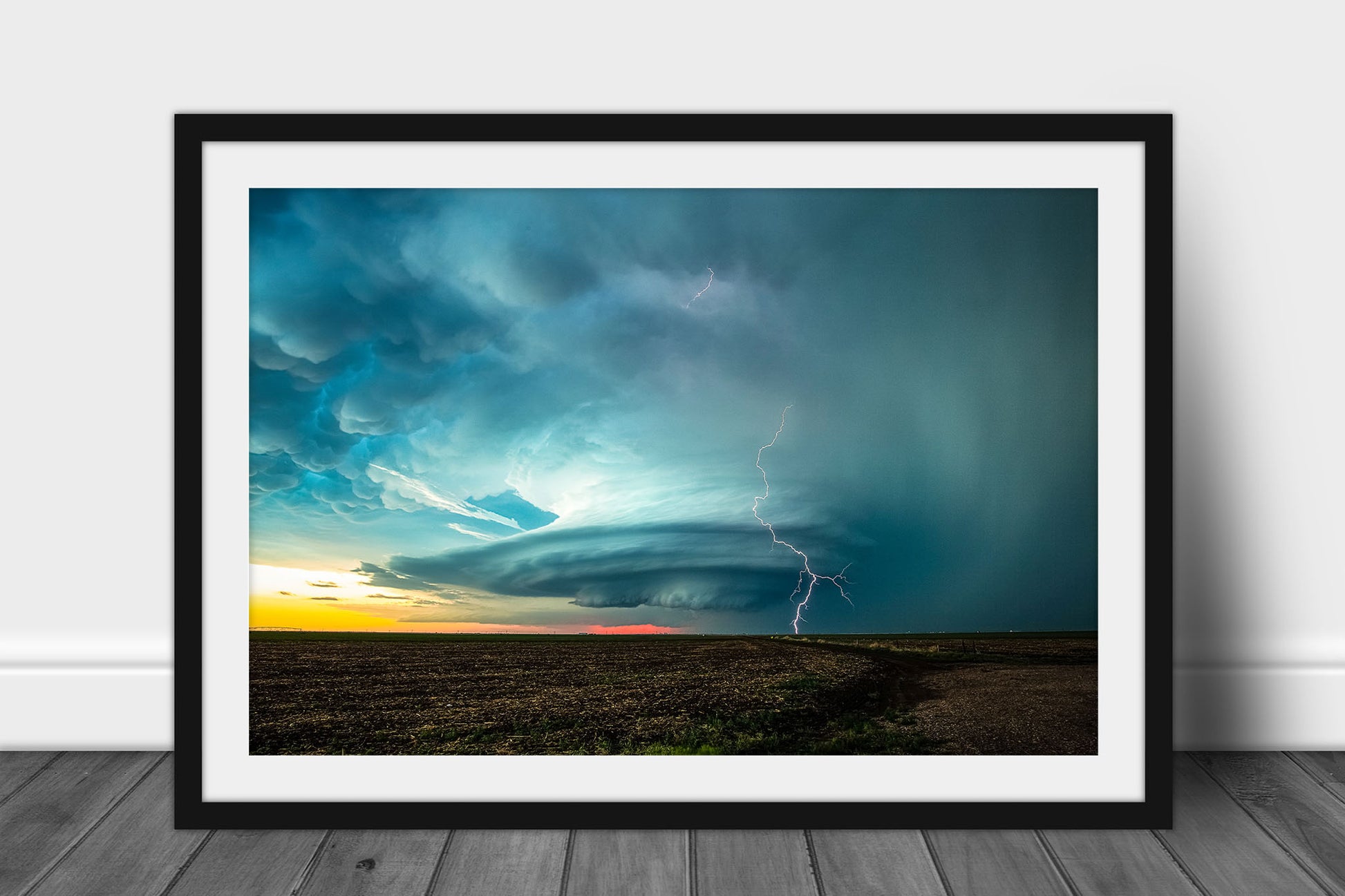 Framed and matted storm photography print of a supercell thunderstorm with lightning bolt over a field at sunset on the plains of Kansas by Sean Ramsey of Southern Plains Photography.