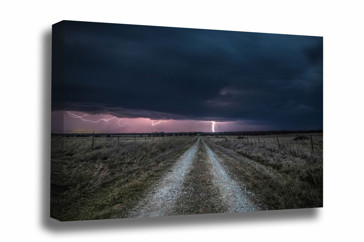 Thunderstorm canvas wall art of lightning striking in the distance down an old country road on a stormy night in Kansas by Sean Ramsey of Southern Plains Photography.