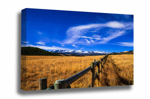 Rocky Mountain canvas wall art of a fence line leading to snow-capped Bighorn Mountains on an autumn day in Wyoming by Sean Ramsey of Southern Plains Photography.