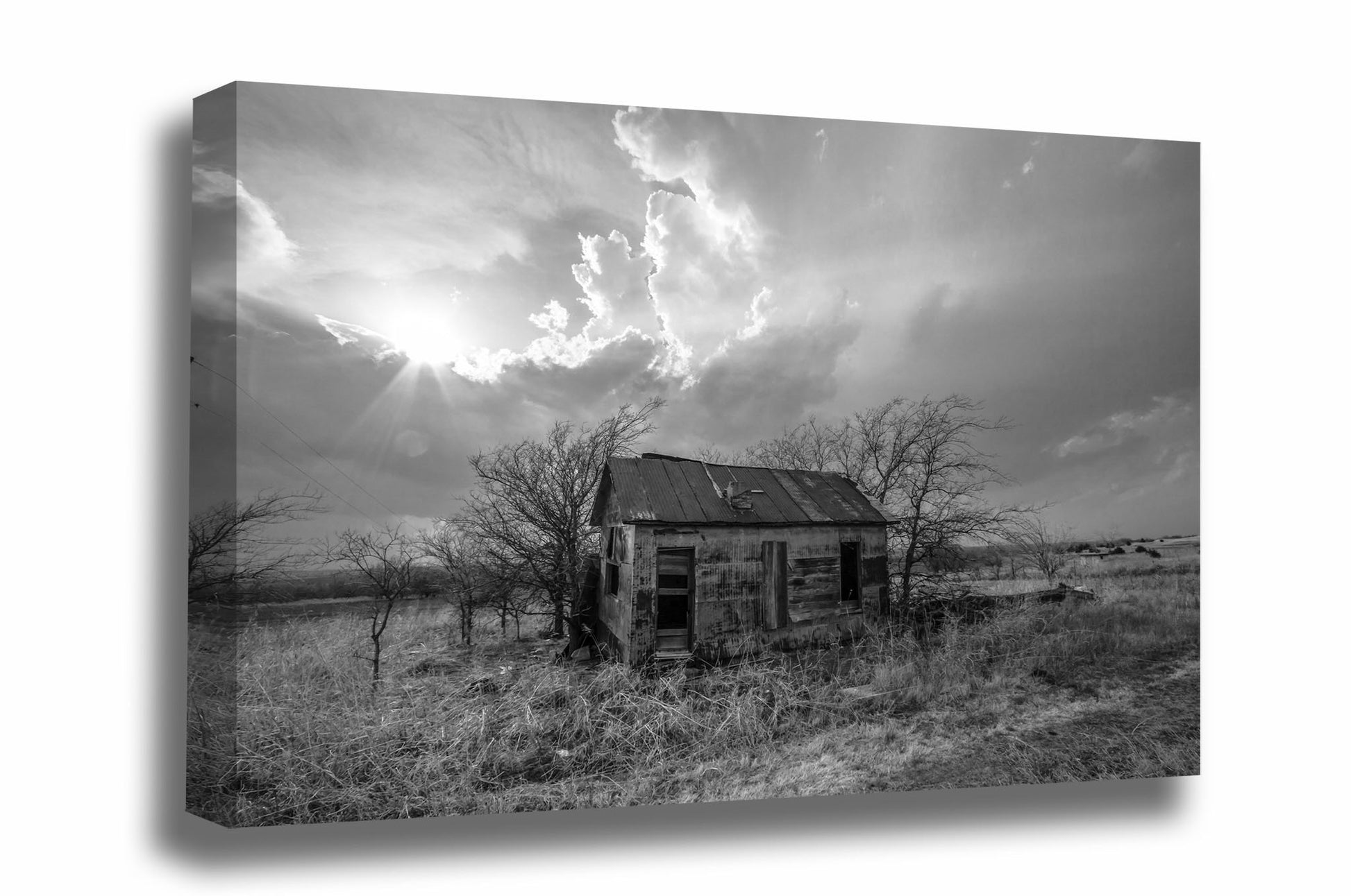 Black and white canvas wall art of sunlight breaking through storm clouds over an abandoned homestead on the Kansas prairie by Sean Ramsey of Southern Plains Photography.
