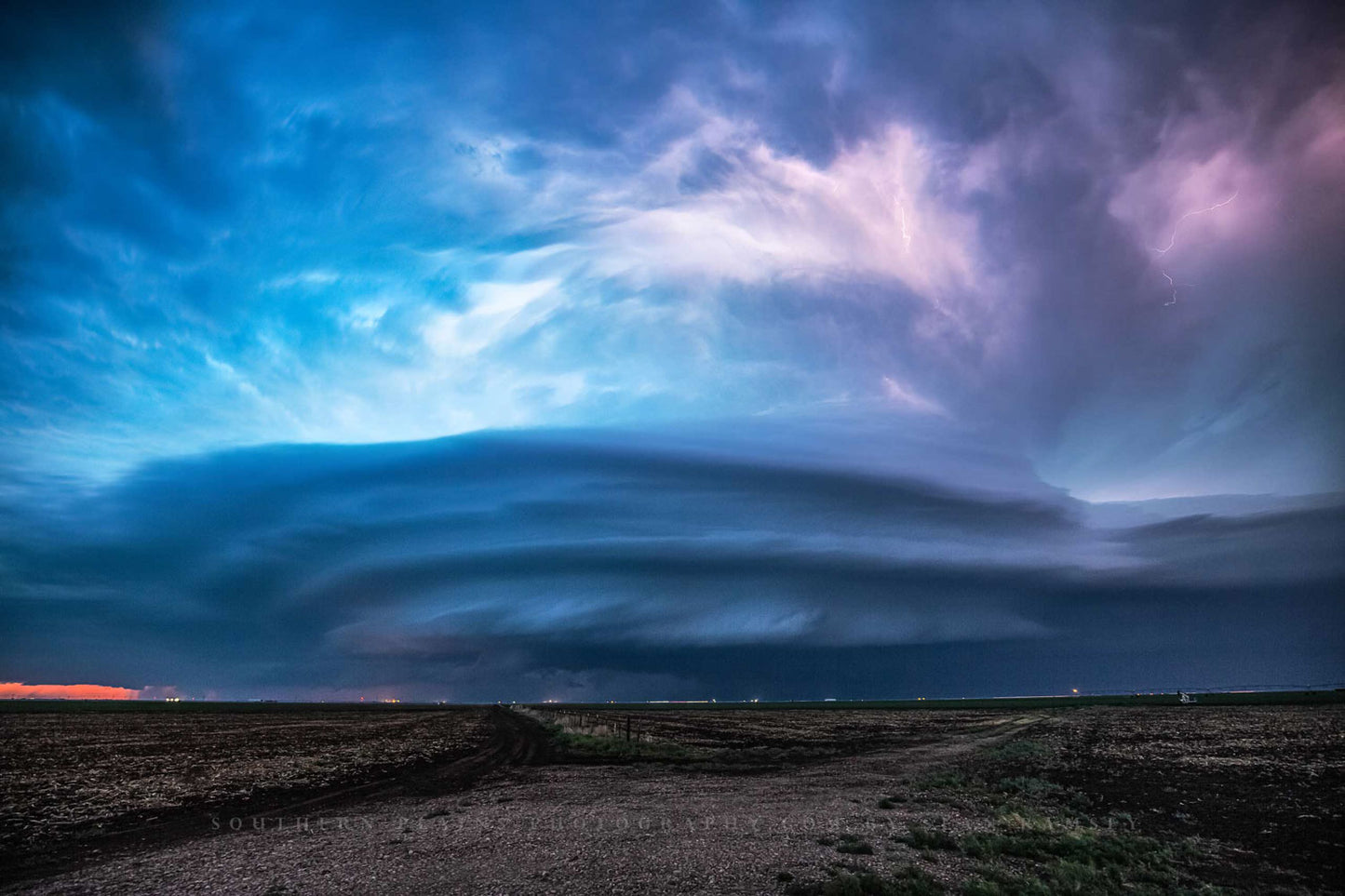 Storm photography print of a supercell thunderstorm illuminated by lightning after dark on a stormy night in Kansas by Sean Ramsey of Southern Plains Photography.