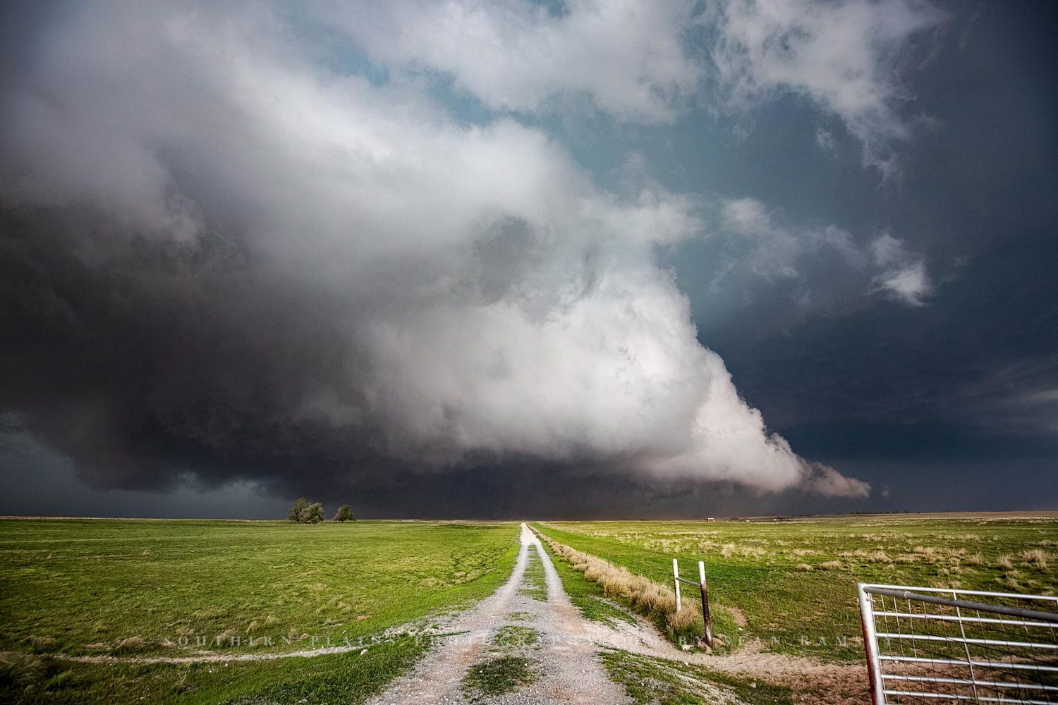 Thunderstorm photography print of a country road leading to a ground scraping storm cloud on a spring day in Oklahoma by Sean Ramsey of Southern Plains Photography.