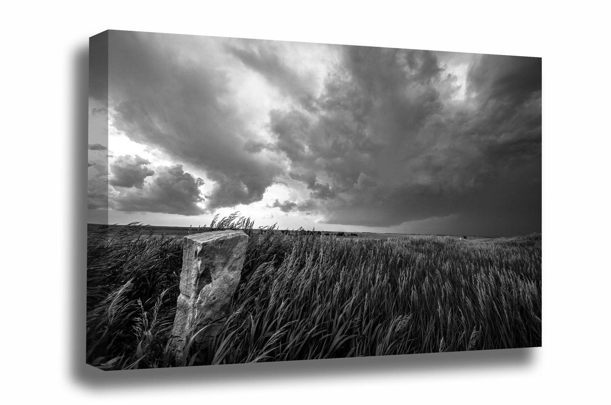 Black and white canvas wall art of a stone marker in waving prairie grass as a storm brews on the horizon in Kansas by Sean Ramsey of Southern Plains Photography.