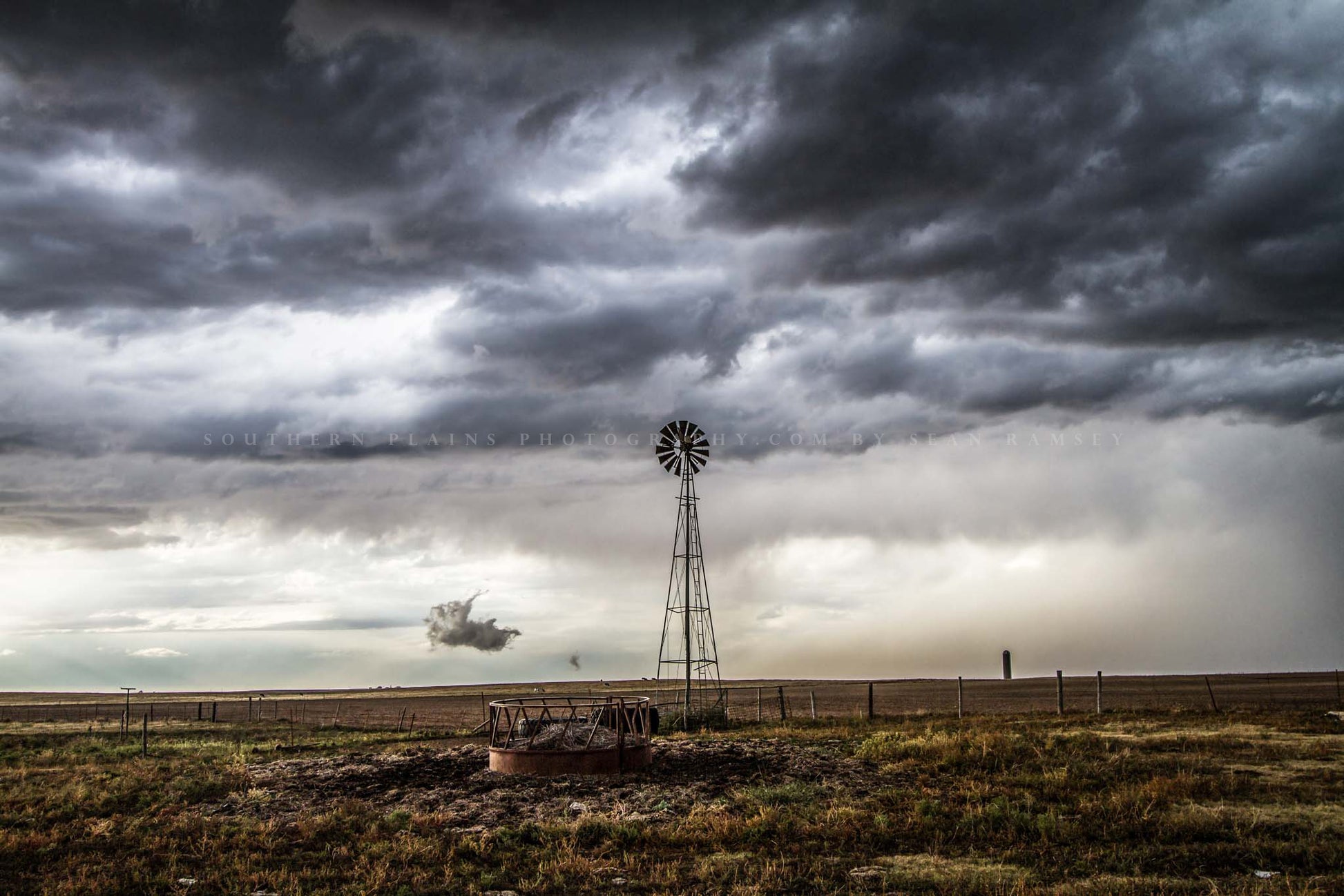 Moody country photography print of an old windmill under a stormy sky on a spring day in the Oklahoma panhandle by Sean Ramsey of Southern Plains Photography.