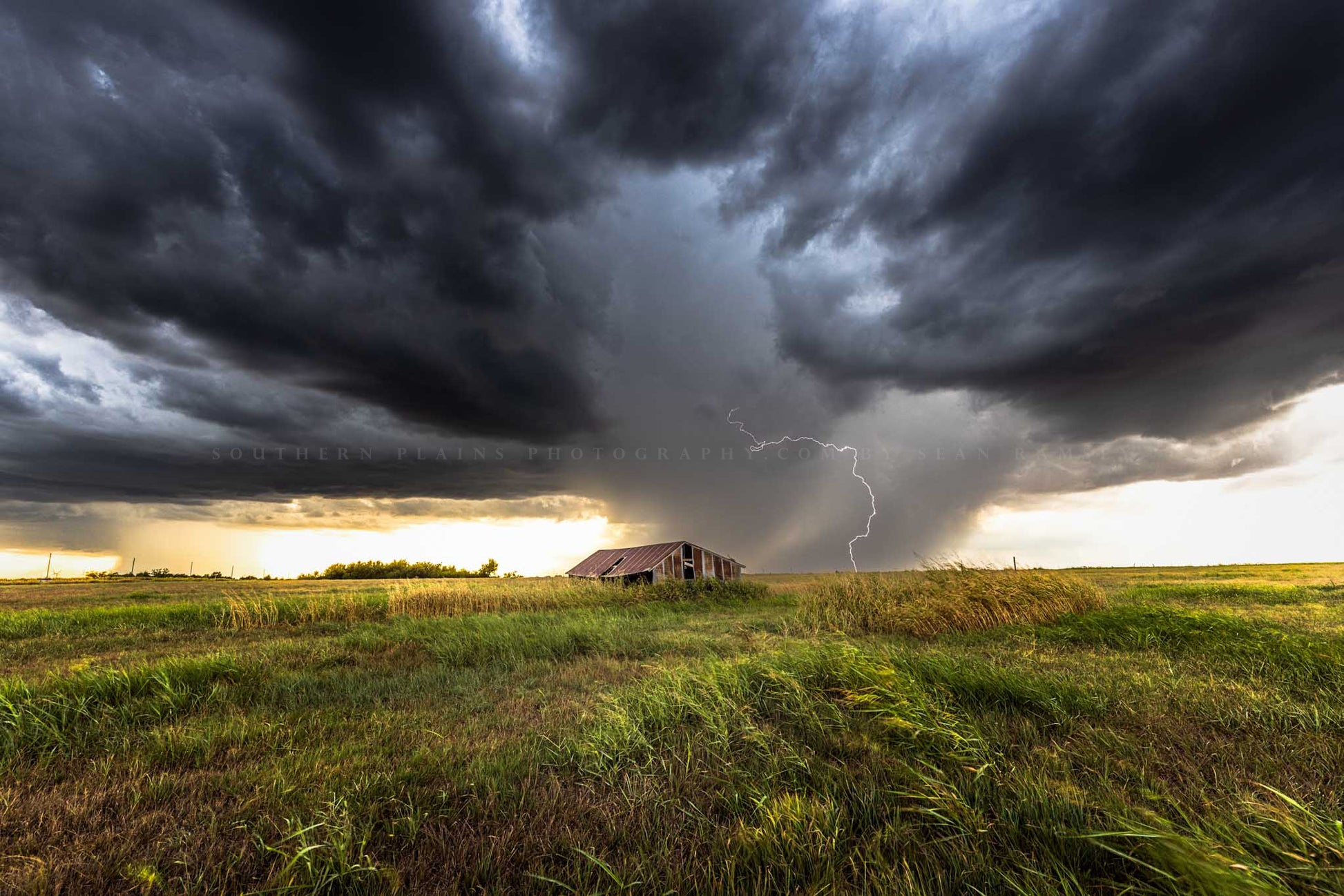 Storm photography print of lightning striking behind a tin covered barn during a summer thunderstorm in Oklahoma by Sean Ramsey of Southern Plains Photography.