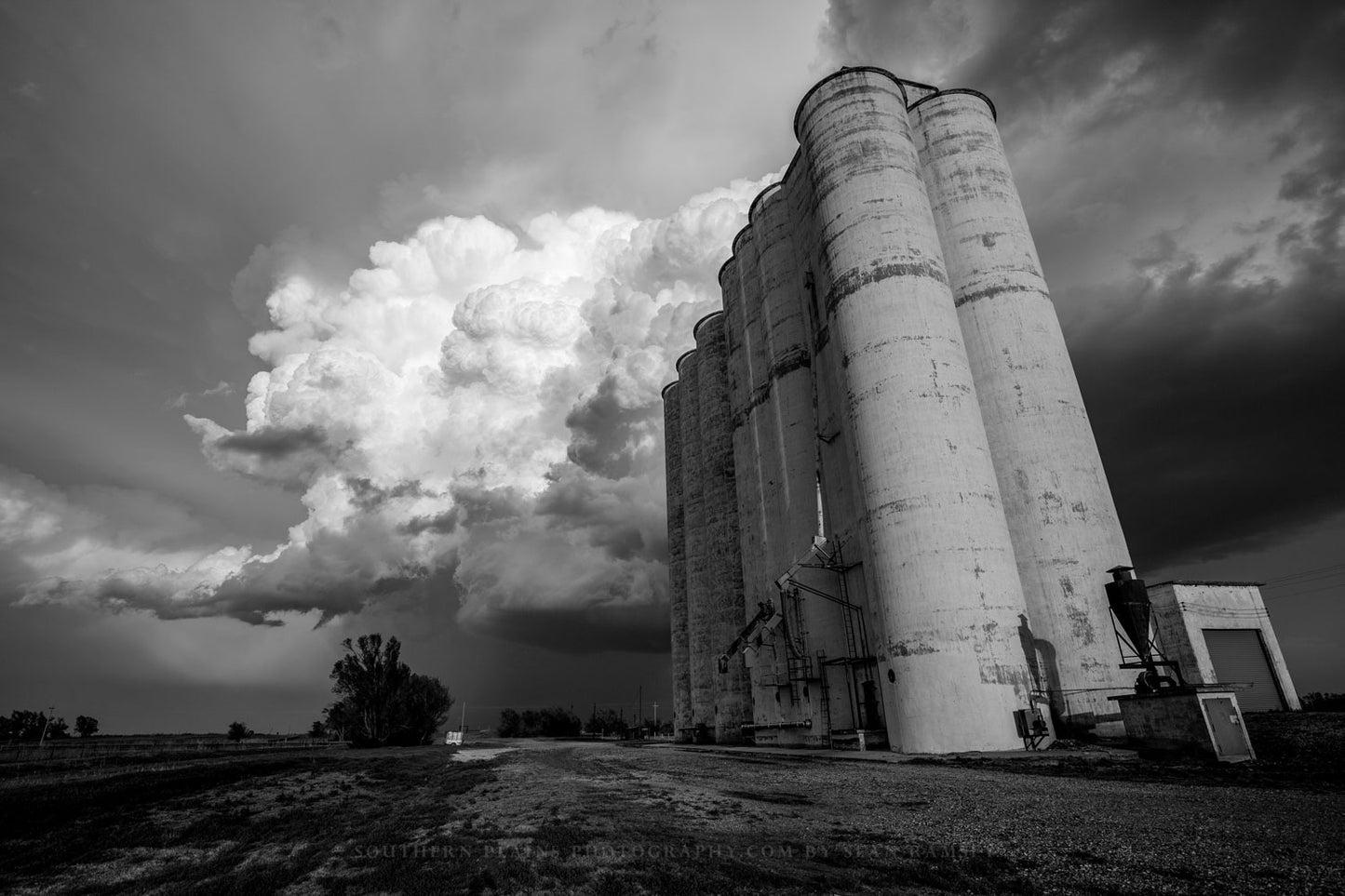 Black and white photography print of a storm cloud over a grain elevator in the ghost town of Sitka, Kansas by Sean Ramsey of Southern Plains Photography.