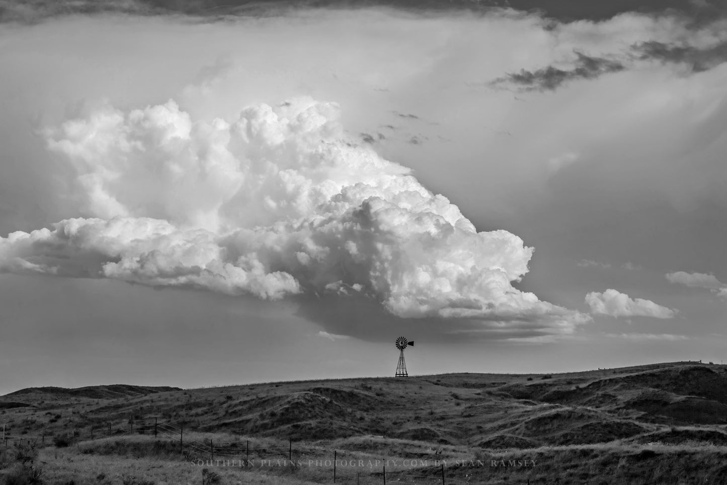 Western photography print of a storm cloud over a windmill on the Nebraska prairie in black and white by Sean Ramsey of Southern Plains Photography.